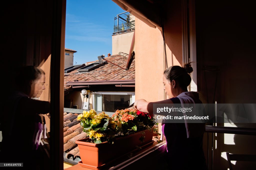 Mature woman gardening in her appartement.