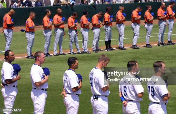 The New York Mets and LA Dodgers salute during the national anthem during the ealry beginnings of the pre-season game in Mexico City 15 March 2003....