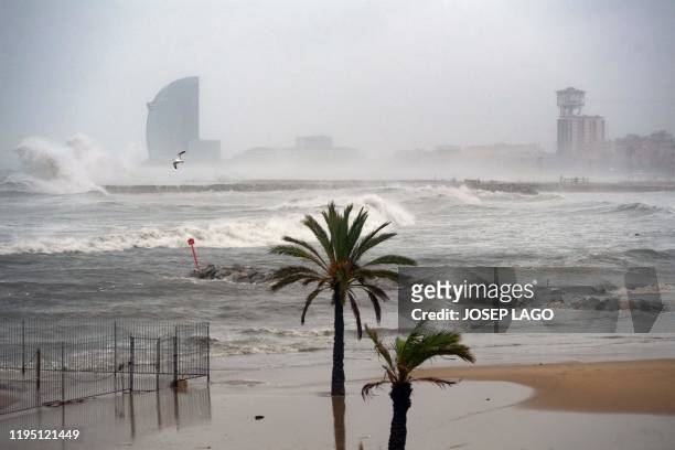 Barcelona hotel is pictured in the mist while big waves hit El Bogatell beach in Barcelona as storm Gloria batters Spanish eastern coast on January...