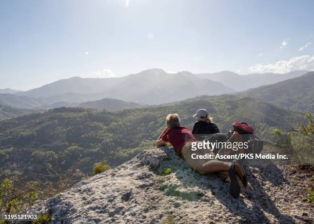 hiking couple relax on rock summit, look at digital tablet - lying on back ストックフォトと画像