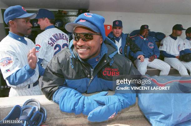 Chicago Cubs' outfielder Dave Clark wears a heavy coat, gloves and a pair of hats as he receives a pat on the back from teammate Doug Glanville in...