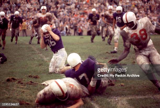 Mark Johnston of the Northwestern Wildcats gets tackled during an NCAA game against the Oklahoma Sooners on September 26, 1959 at Dyche Stadium in...