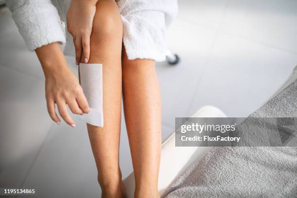 young woman waxing legs - wax stock pictures, royalty-free photos & images