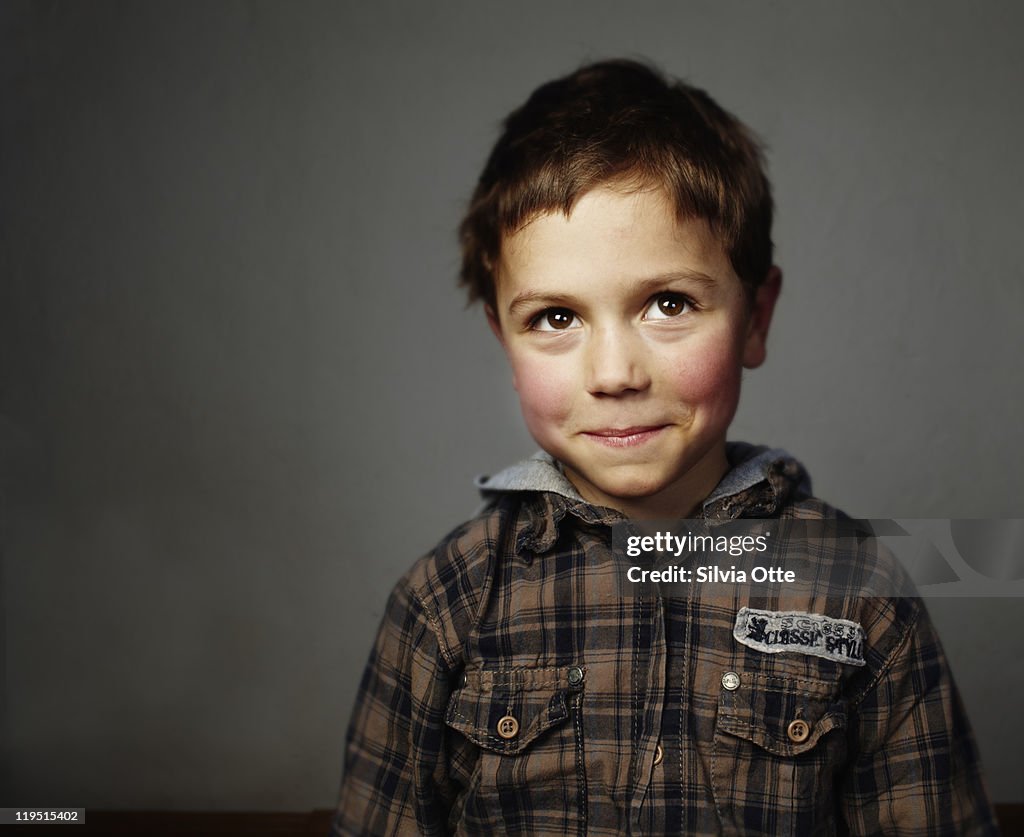 Boy smiling shy at camera