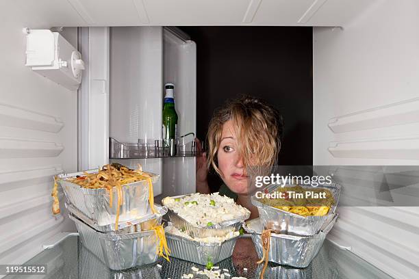 woman finds take-out food containers in fridge. - guilty stock pictures, royalty-free photos & images