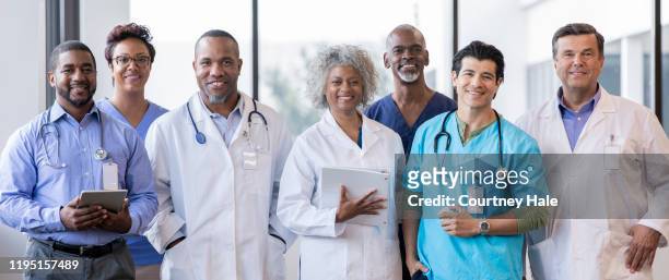 gruppe von medizinern lächeln zusammen für ein foto - smile black white stock-fotos und bilder