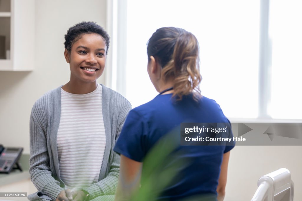 Mid adult woman receiving good news from nurse