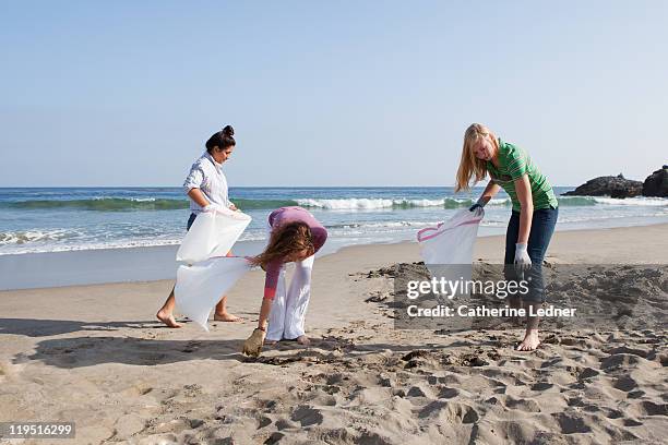 teenage girls volunteering beach cleanup - three girls at beach stock pictures, royalty-free photos & images