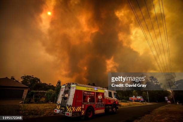 Firemen prepare as a bushfire approaches homes on the outskirts of the town of Bargo on December 21, 2019 in Sydney, Australia. A catastrophic fire...