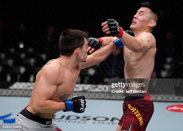 Ryan Benoit punches Alatengheili of China in their bantamweight fight during the UFC Fight Night event at Sajik Arena 3 on December 21, 2019 in...