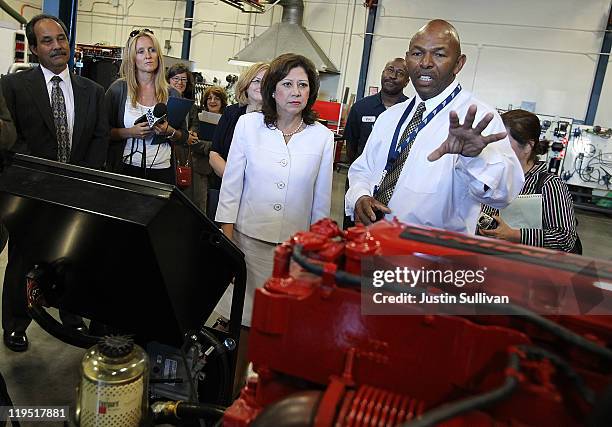 Secretary of Labor Hilda Solis looks at a hybrid bus engine with Santa Clara Valley Transportation Authority maintenance training supervisor Russell...