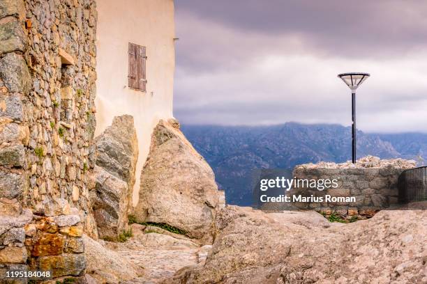 street light, walls, and stone street in a typical corsican mountain village. sant'antonino, haute-corse, corsica, france. - haute corse bildbanksfoton och bilder