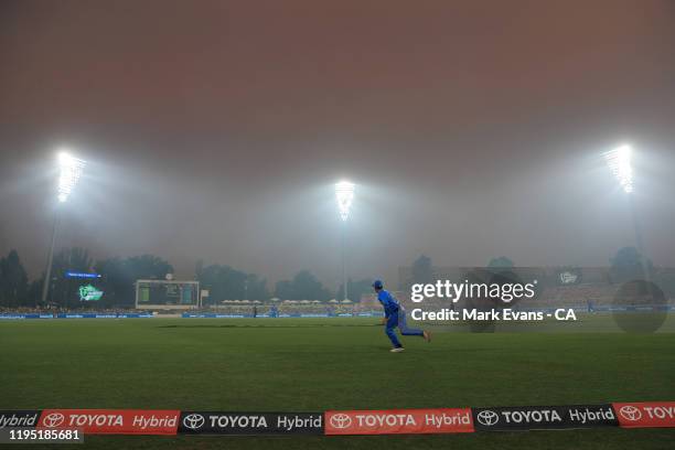 Bushfire smoke covers the ground uring the Big Bash League match between the Sydney Thunder and the Adelaide Strikers at Manuka Oval on December 21,...