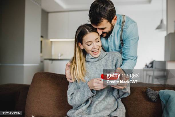 young romantic couple holding present - surprise gift for girlfriend stock pictures, royalty-free photos & images