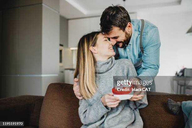 young romantic couple holding present - falling in love stock pictures, royalty-free photos & images