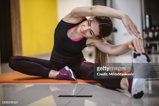 fitness-frau machen dehnübungen - frau macht yoga stock-fotos und bilder