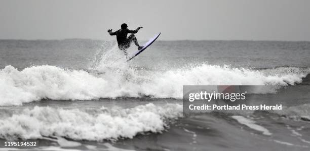 Surfer catches some air as he rides a wave at Higgins Beach in Scarborough Monday, Jan.13, 2019.