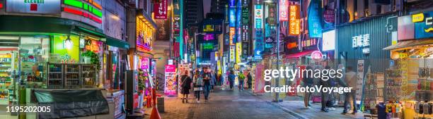 neon night shopping street myeong-dong shopping district panorama seoul korea - seul stock pictures, royalty-free photos & images