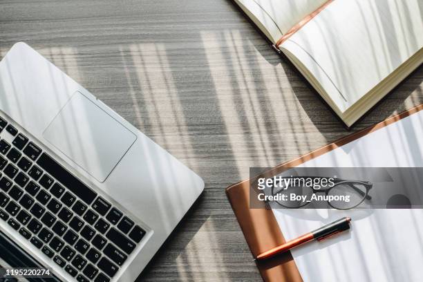 top view of office table desk with notebook, computer, paper, pencil, eyeglasses the accessories for office work. - overhead business shadows stock pictures, royalty-free photos & images