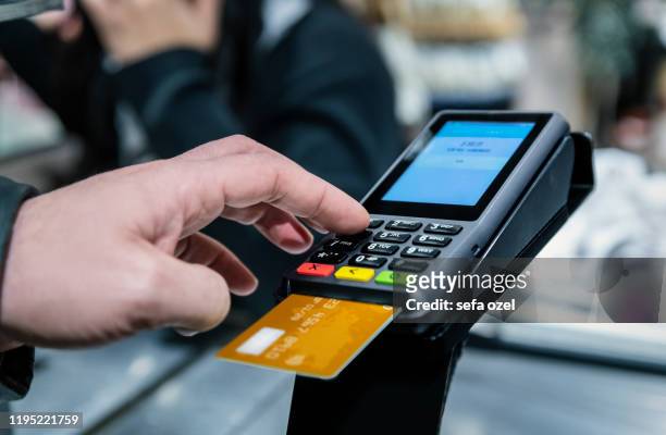 man paying shopping with credit card pin entry in the supermarket - system stock pictures, royalty-free photos & images