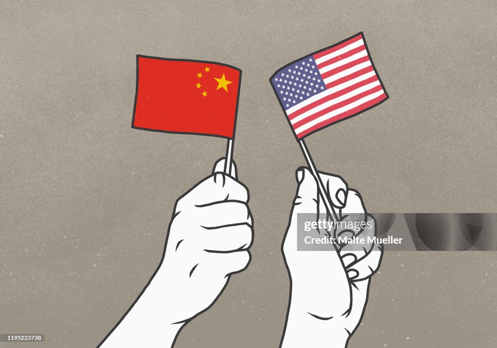 Hands waving small American and Chinese flags