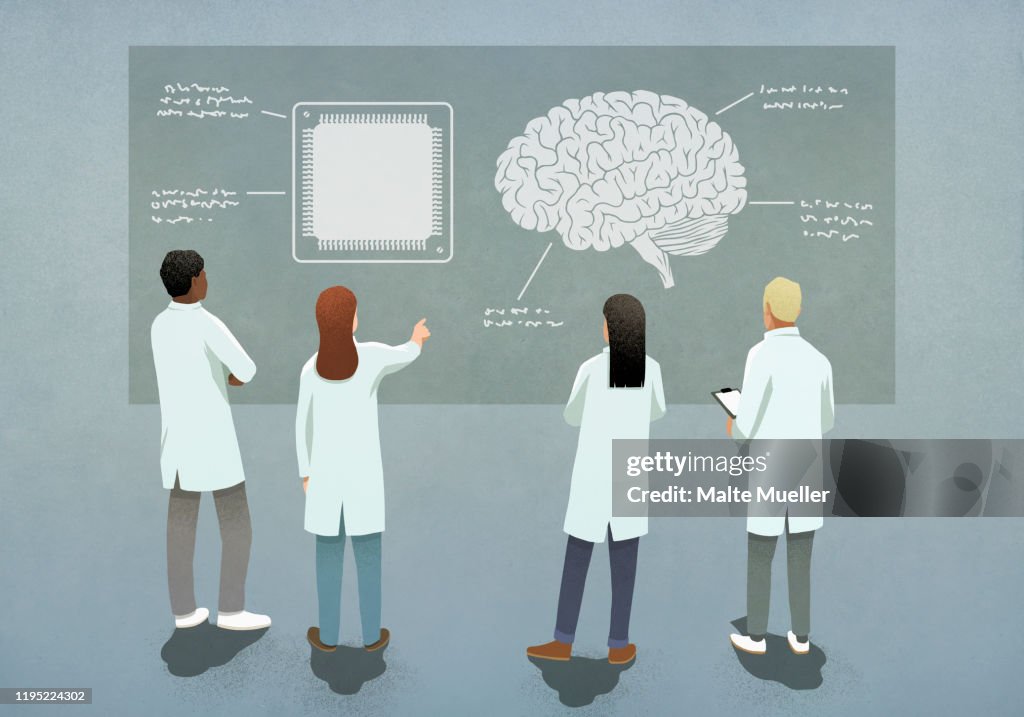 Scientists comparing computer chip and brain diagram