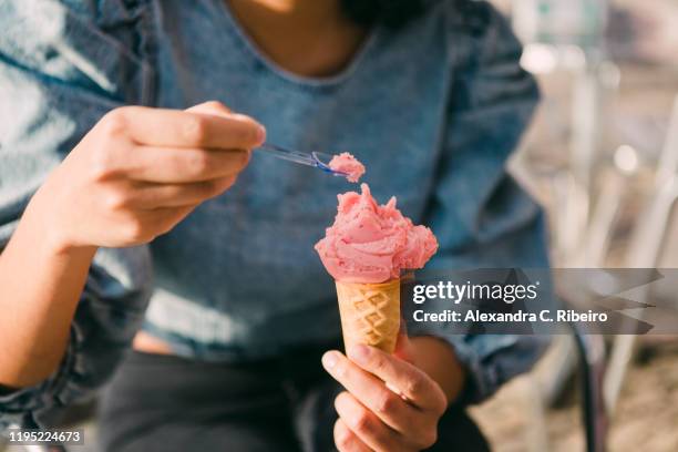 close up woman eating pink ice cream cone - mulher colher sorvete imagens e fotografias de stock