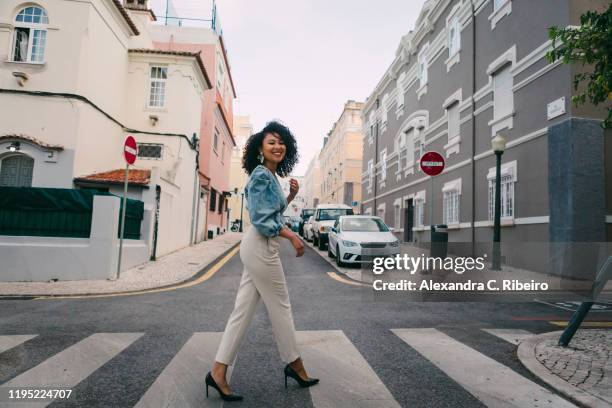 portrait happy, stylish woman crossing city street - street side stock-fotos und bilder