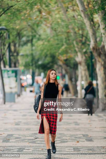 stylish young woman walking in urban park - falda fotografías e imágenes de stock