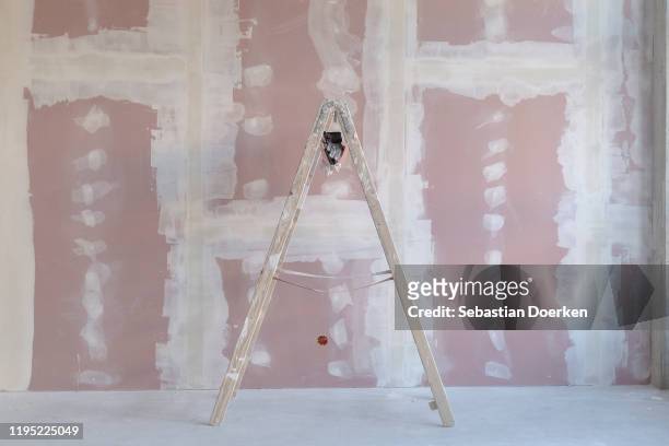 ladder against wall at construction site - gips bouwmateriaal stockfoto's en -beelden