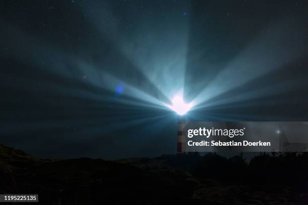 light beacons illuminating from lighthouse under starry night sky, wittduen, germany - beacon stock pictures, royalty-free photos & images