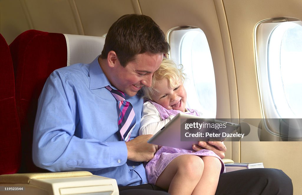 Father entertaining daughter on plane