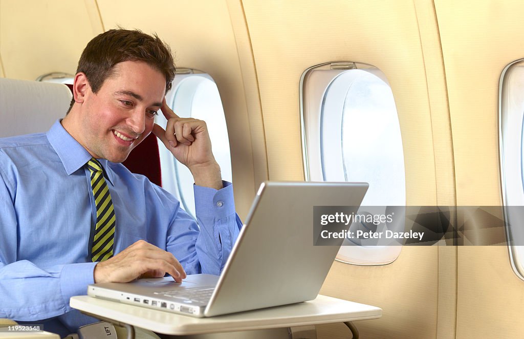 Businessman in first class seat on airplane