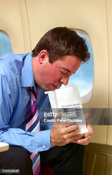 businessman being sick on plane - sick bag fotografías e imágenes de stock