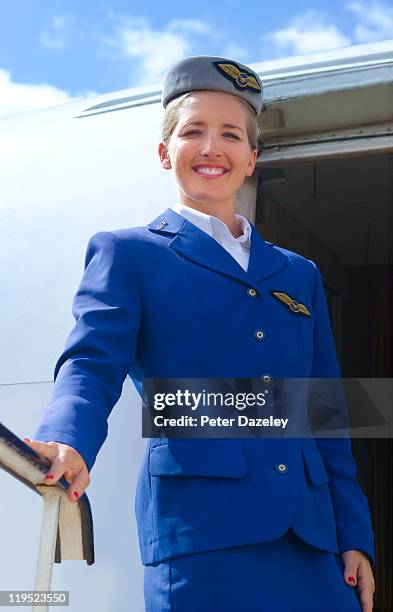 air hostess on steps of plane - stewardess stock-fotos und bilder