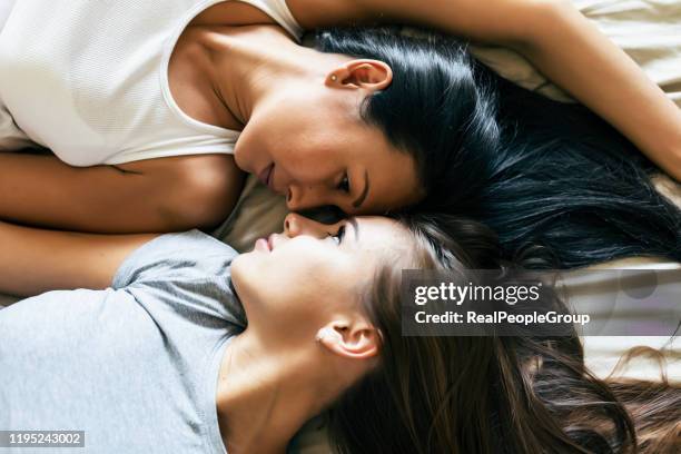two young lesbians sharing the love emotions in the bedroom - lesbians kissing stock pictures, royalty-free photos & images
