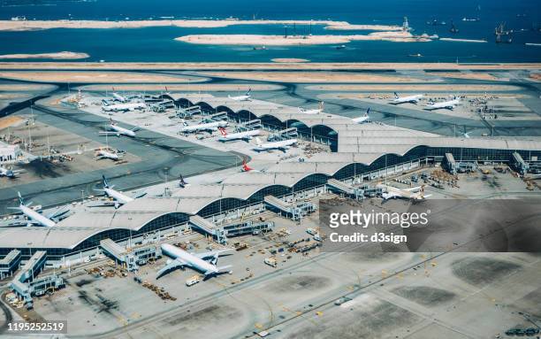 aerial view of hong kong international airport with planes parking on the tarmac - aerial hong kong stock-fotos und bilder