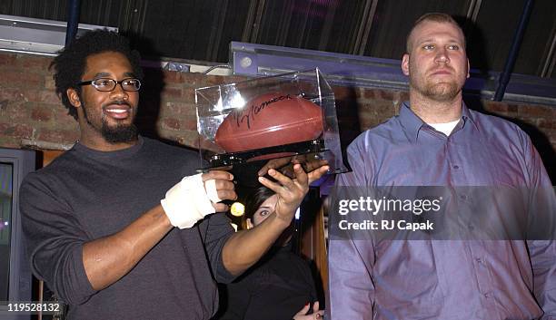 Dhani Jones & Jason Fabini , with Joe Namath signed football, some of the sports memorabilia being auctioned off