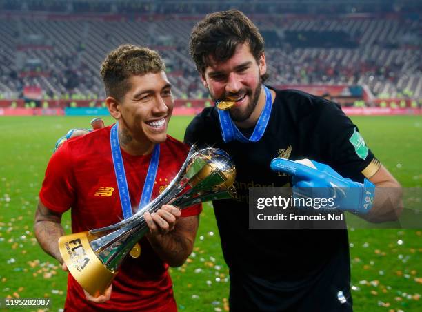 Roberto Firmino and Alisson Becker of Liverpool pose with the FIFA Club World Cup trophy following their victory in the FIFA Club World Cup Qatar...