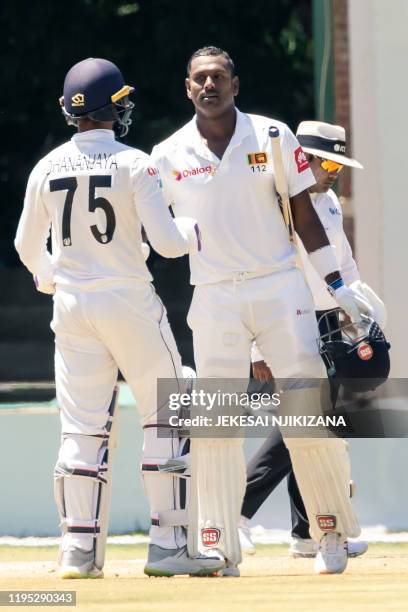 Sri Lanka's Angelo Mathews celebrates with teammate Sri Lanka's Dhananjaya de Silva after scoring a century during the fourth day of the first Test...