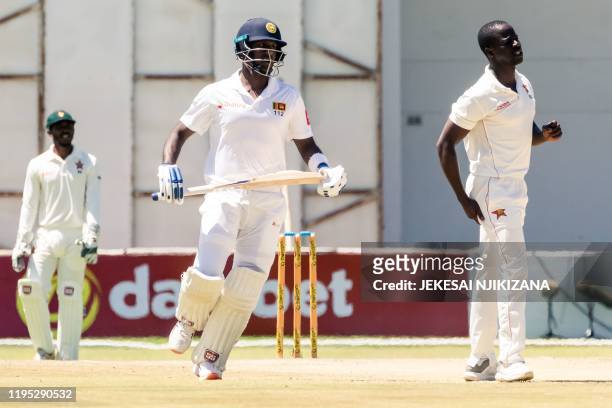 Sri Lanka's Angelo Mathews runs between the wickets past Zimbabwe's Donald Tiripano during the fourth day of the first Test cricket match between...