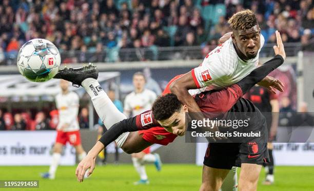 Nordi Mukiele of RB Leipzig jumps for a header with Ruben Vargas of FC Augsburg during the Bundesliga match between RB Leipzig and FC Augsburg at Red...