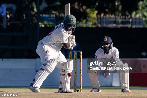 Zimbabwe's batsman Prince Masvaure prepares to hit the ball past wicket keeper Niroshan Dickwella during the fourth day of the first Test cricket...