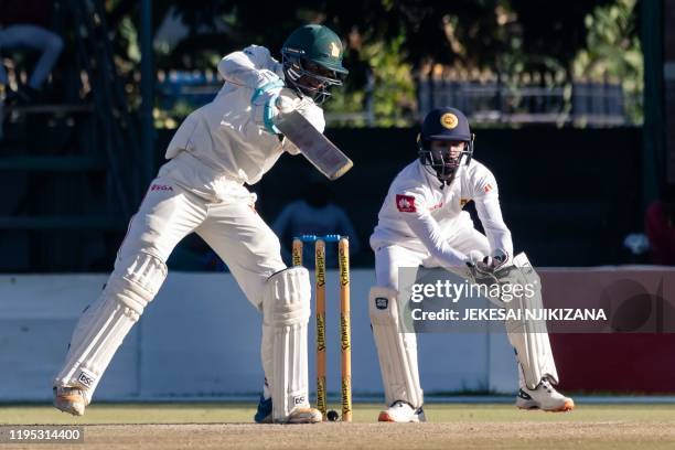 Zimbabwe's batsman Brian Mudzinganyama hits the ball past wicket keeper Niroshan Dickwella during the fourth day of the first Test cricket match...