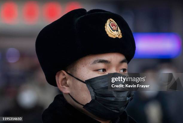 Chinese police officer wears a protective mask while patrolling at Beijing Station before the annual Spring Festival on January 22, 2020 in Beijing,...