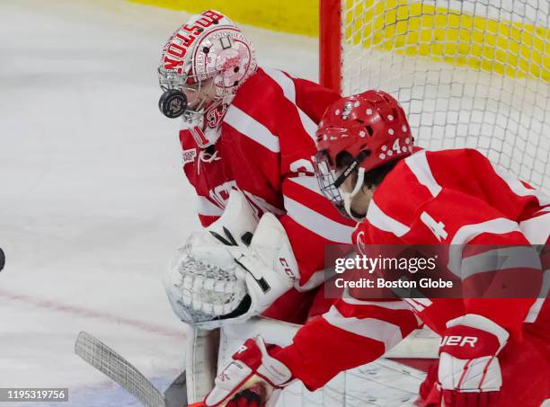 Boston University goalie Sam Tucker uses his face mask to make a save against Boston College during the first period at Silvio O. Conte Forum in...