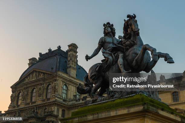 paris, france - february 12, 2015: louvre museum at dusk on february 12, 2015 in paris. this is one of the most popular tourist destinations in france displayed over 60,000 square meters of exhibition space. - louvre pyramid stock-fotos und bilder