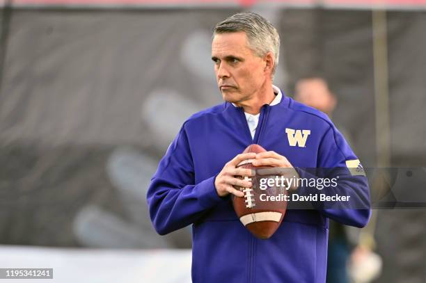 Head coach Chris Petersen of the Washington Huskies looks on as his team warms up prior to a game against the Boise State Broncos in the Mitsubishi...