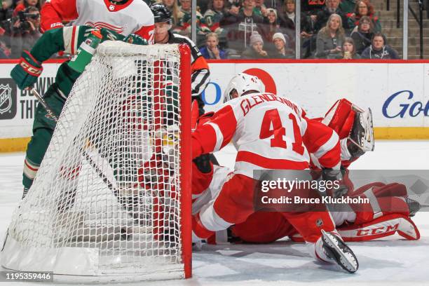 Zach Parise of the Minnesota Wild scores a goal against Luke Glendening and Jimmy Howard of the Detroit Red Wings during the game at the Xcel Energy...