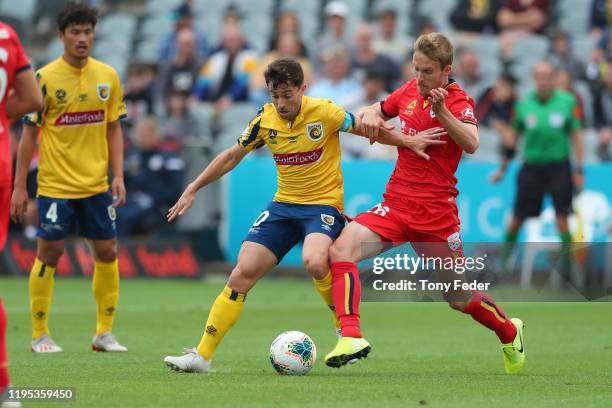 Tommy Oar of the Central Coast Mariners contests the ball with Ben Halloran of Adelaide United during the round 11 A-League match between the Central...